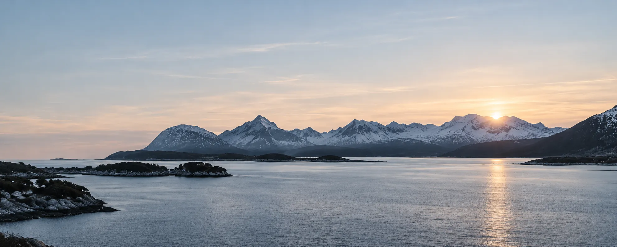 Nordisk fjord med snötäckta berg i det sista dagsljuset.
